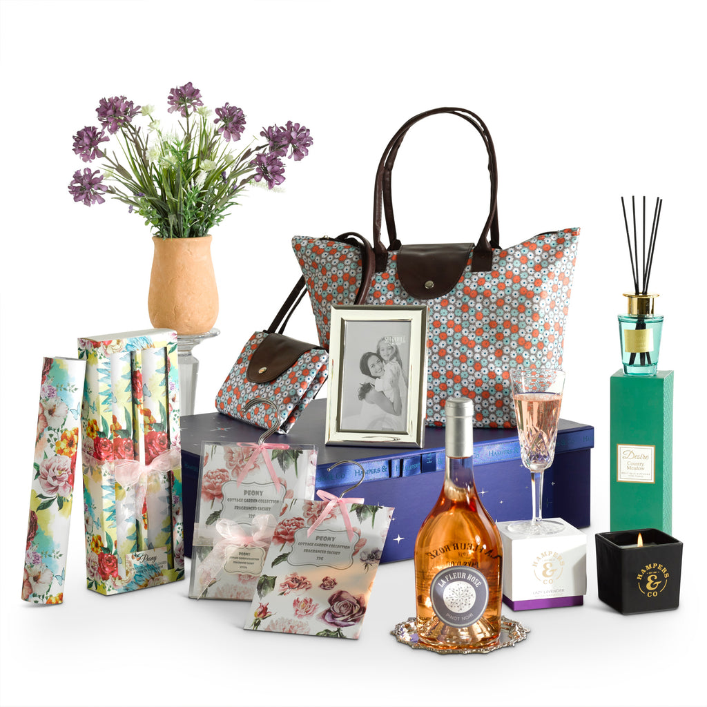 A collection of beautiful things, containing a bottle of Rosé, desire diffuser, drawer hanging sachets, fragrant drawer liners, silver plated photo frame, a floral display and lavender candle presented in a elegant gift box